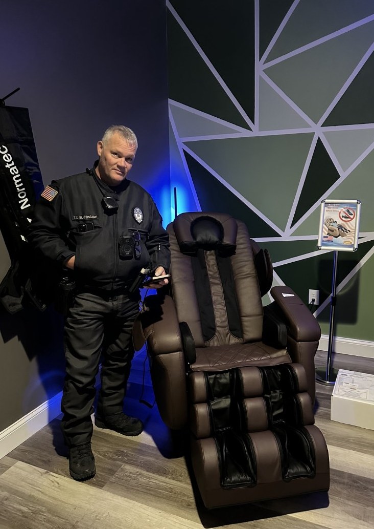 Garland Police Department officer standing beside a Luraco Care Chair in the department wellness room